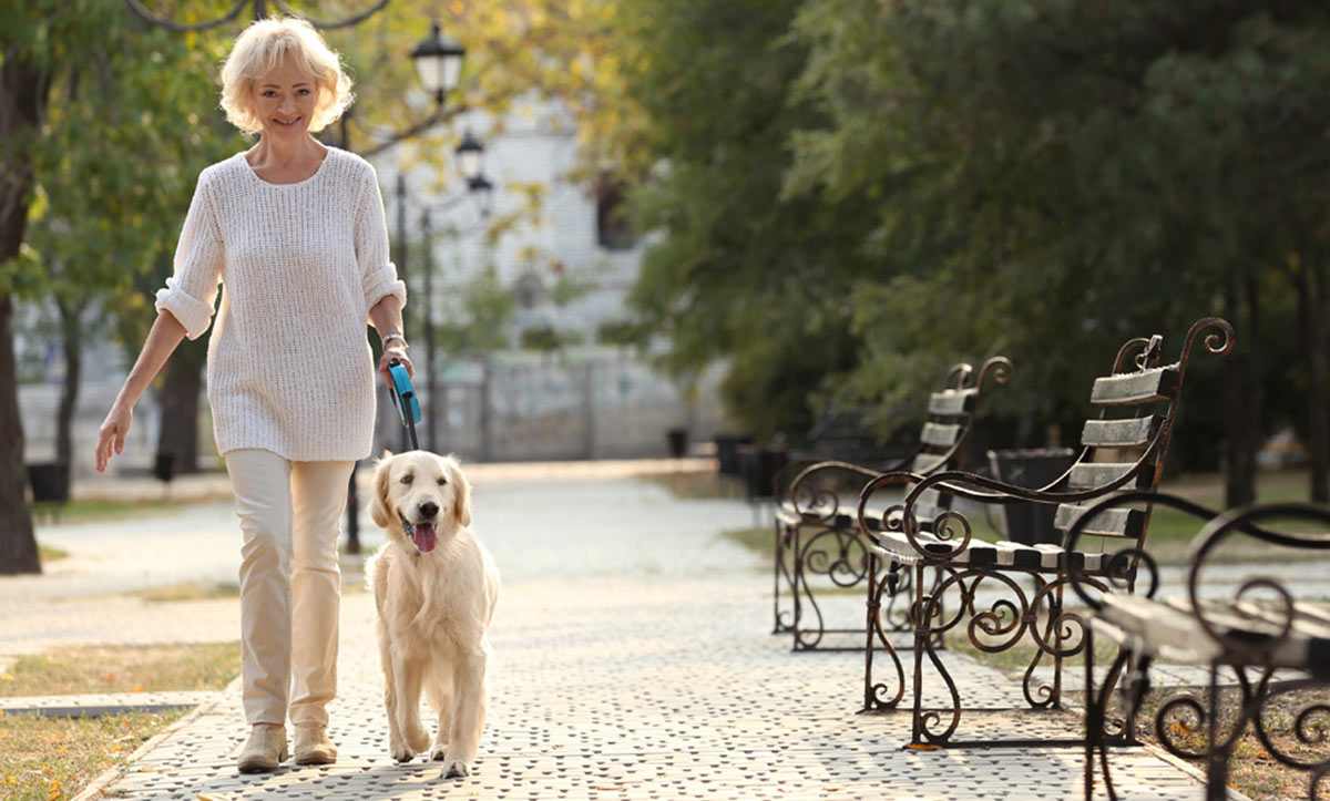 Woman walking dog outside. Medication mismanagement and fall prevention.