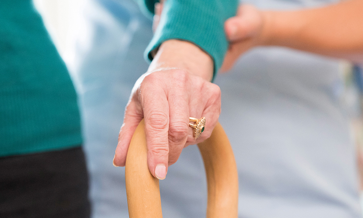 Image of a female hand holding a walking cane.