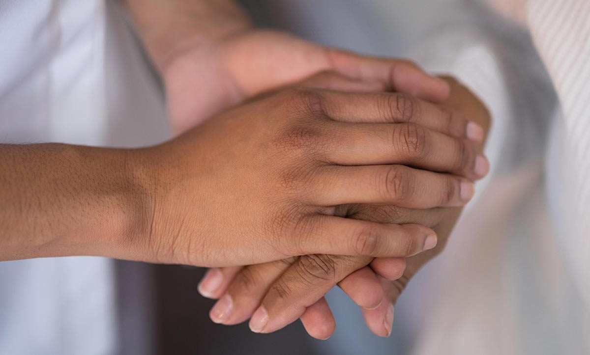 Closeup image of two people holding hands.