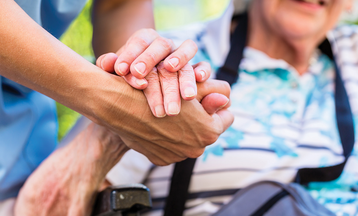 person holding the hand of another person, hospice and palliative care