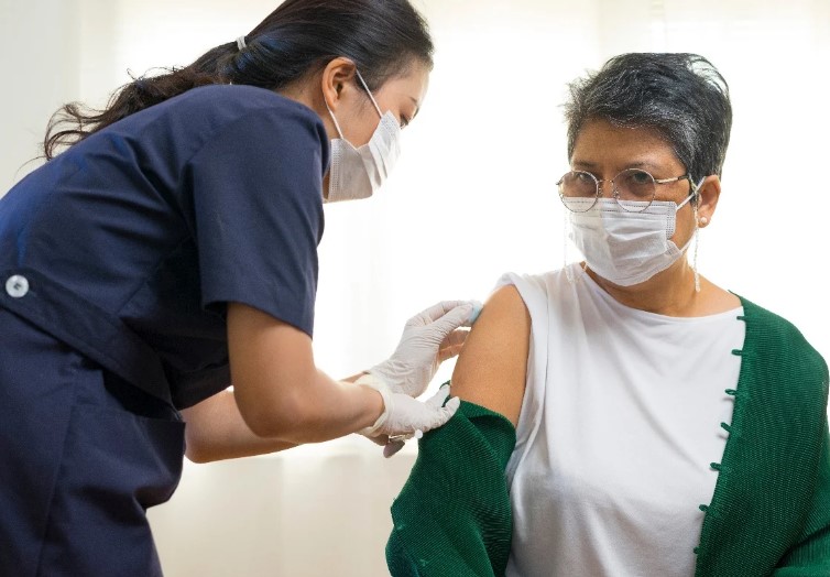 woman receiving a vaccine from female health care provider