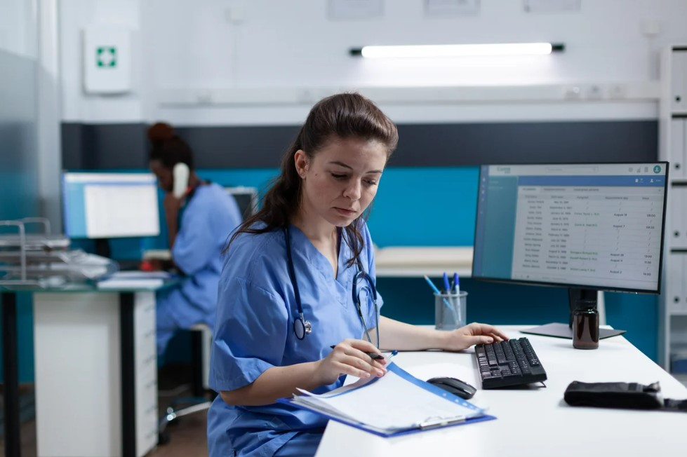 nurse at desk, busy with paperwork