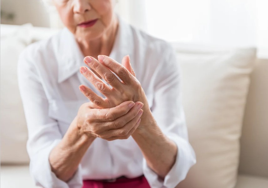 senior woman gripping hand in pain