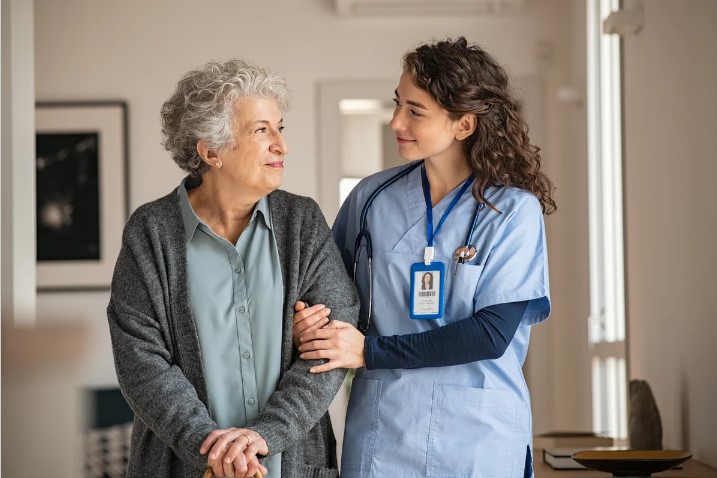 female resident walking arm in arm with nurse