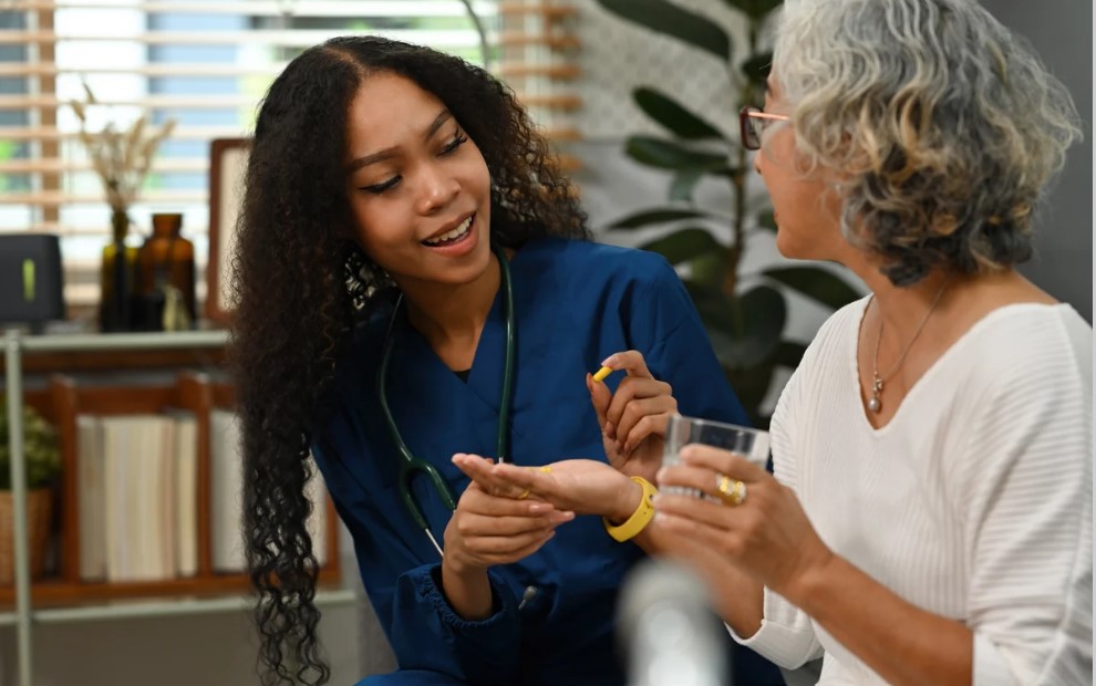 nurse providing medication to a female resident