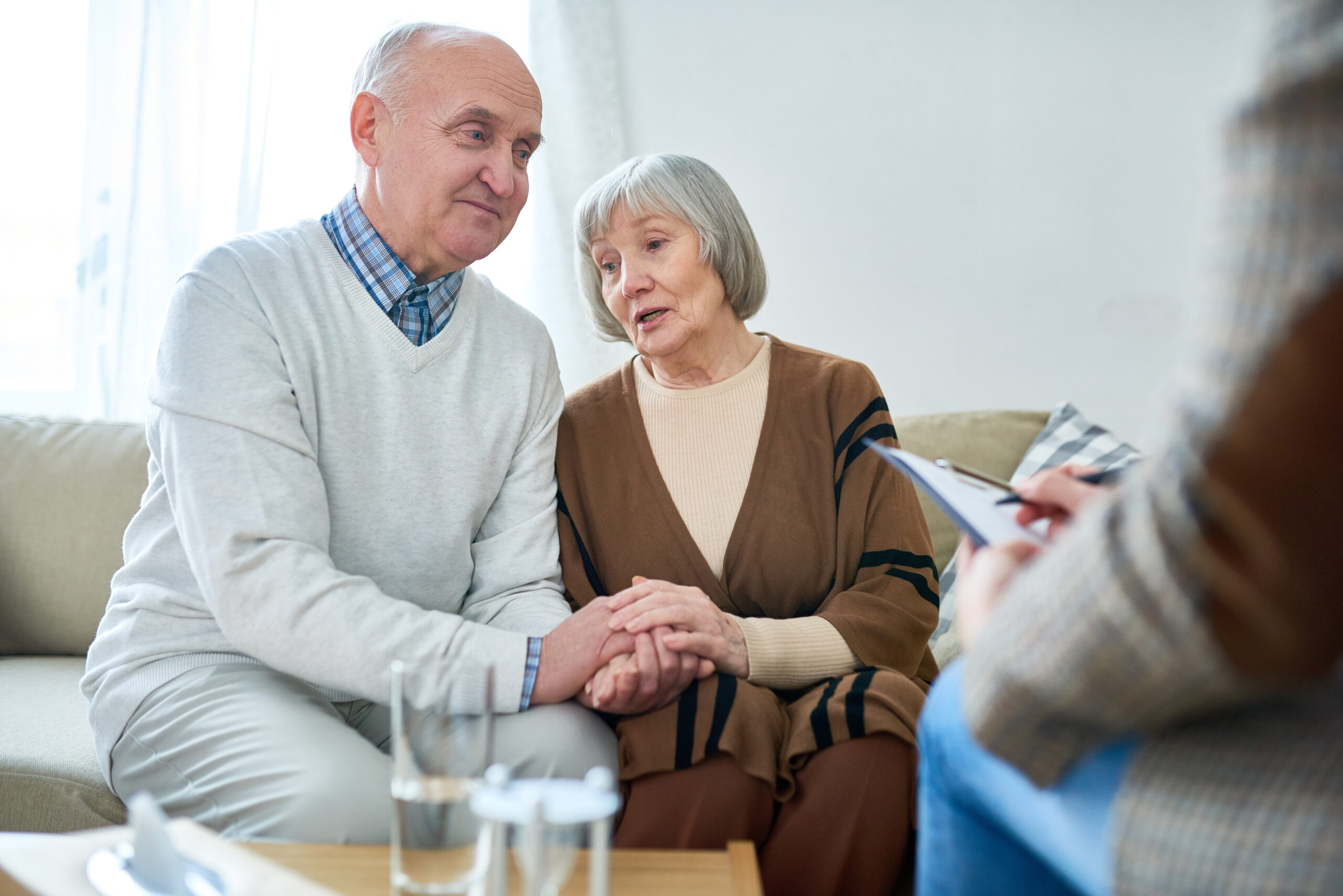 senior man and woman talking to a therapist