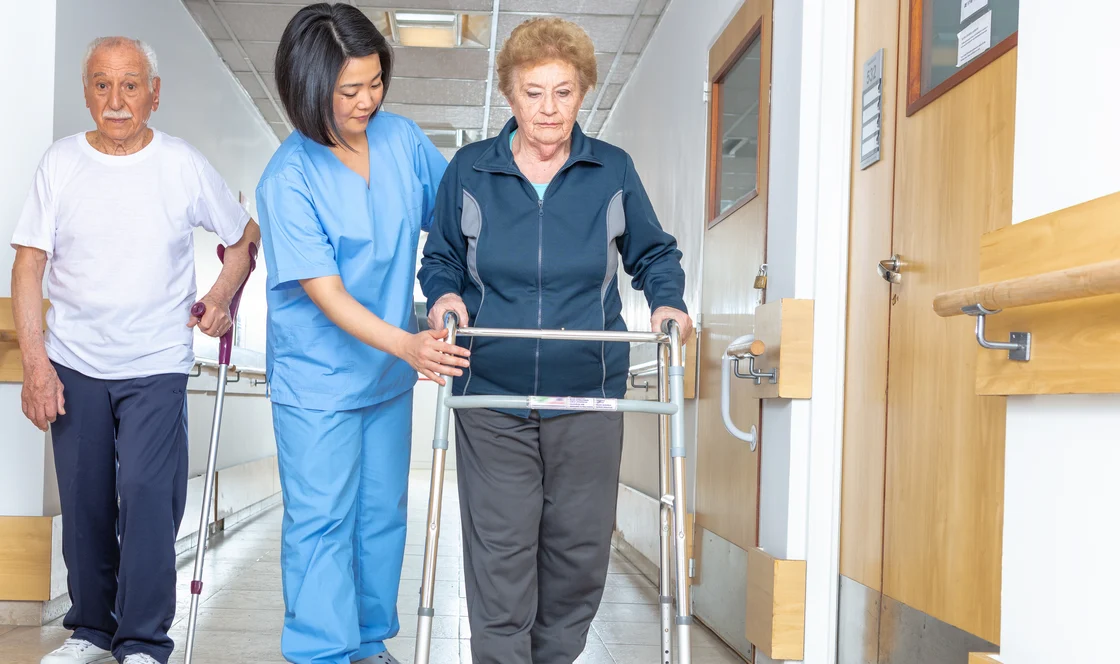 nurse helping woman with walker